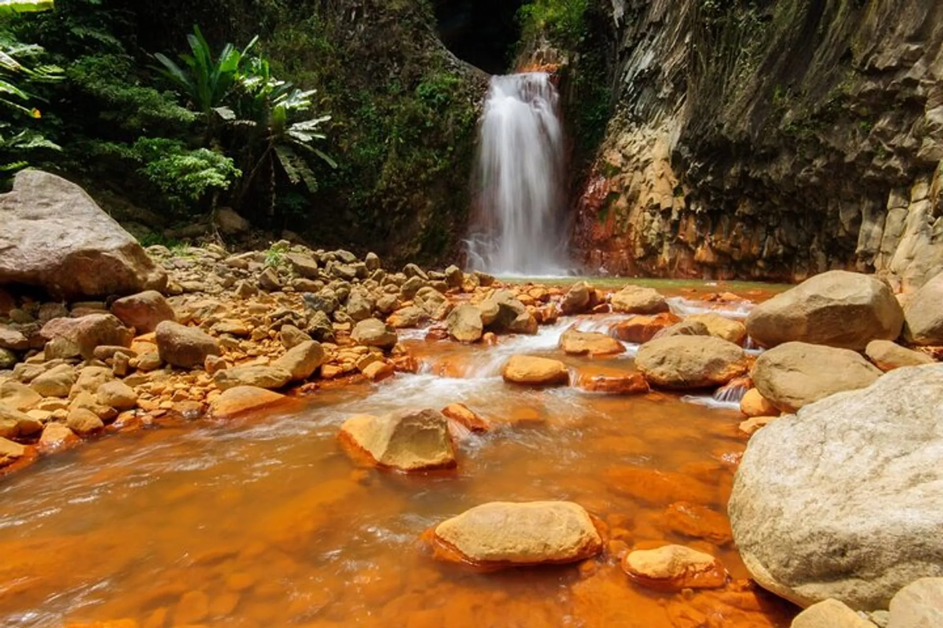 Red-colored rocks and steaming hot spring waters.